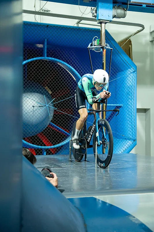 Ciclista realizando pruebas de resistencia aerodinámica sobre la biciclieta, bajo la supervisión de Luis Lamas Vázquez, Biomecánico Deportivo y Mecánico del equipo Decathlon – CMA CGM