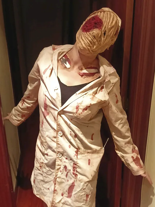 Mujer caracterizada para Halloween con maquillaje facial y corporal de terror que simula heridas y sangre
