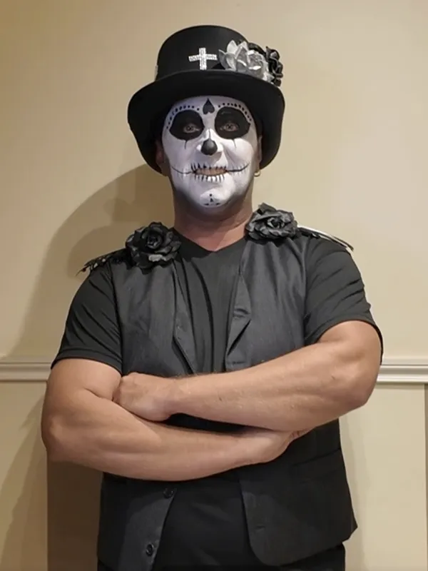 Hombre caracterizado con maquillaje inspirado en el Día de los Muertos mexicano para Halloween o carnaval