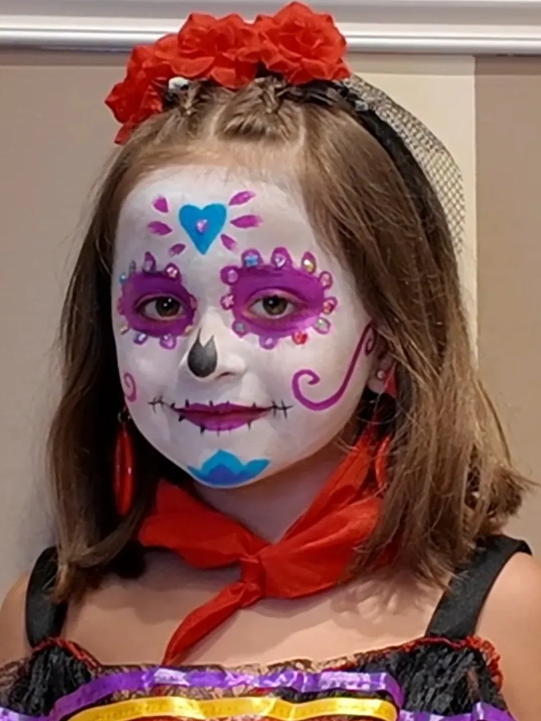 Niña caracterizada con maquillaje inspirado en el Día de los Muertos mexicano para Halloween o carnaval