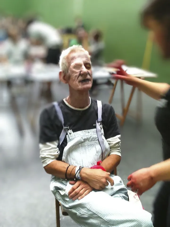 Tania Porcel maquillando a un hombre caracterizado como zombi para Halloween
