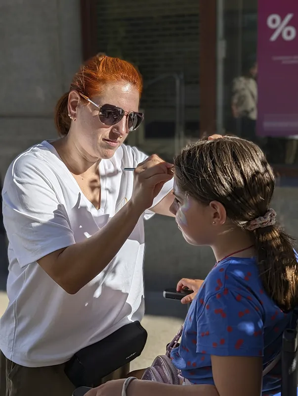 Tania Porcel realizando un diseño de pintacaras en la frente de una niña durante las fiestas de Erandio