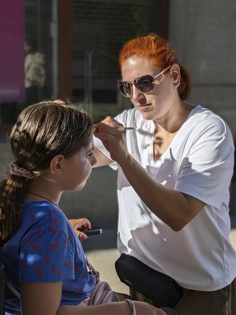 Tania Porcel realizando un dibujo de maquillaje de fantasía en la pierna durante un evento en fiestas de Erandio, Bizkaia